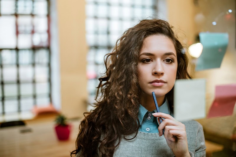 teenage girl looking at post it on a glass